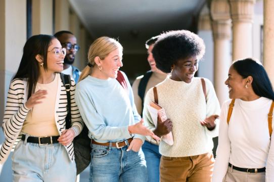 A diverse group of young adults walking together and smiling, representing community, connection, and inclusion