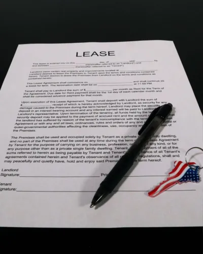 Rental lease with a pen and house key.